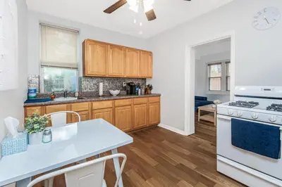 a kitchen with wooden cabinets and a white stove top oven at Cozy cottage close to NYC in Yonkers