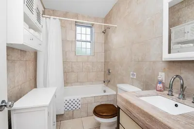 a bathroom with a tub and a toilet and a sink at Cozy cottage close to NYC in Yonkers