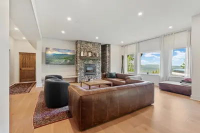 a living room with a leather couch and a fireplace at Windham Slopes - Ski-In-Out, Hot Tub & Fire Pit in Windham