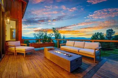 a living room with a couch and a table on a deck at Windham Slopes - Ski-In-Out, Hot Tub & Fire Pit in Windham