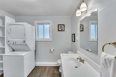 a white bathroom with a sink and a toilet at The Main Lineup Apt 4 - All Star Baseball Rentals in Oneonta