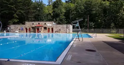 a large swimming pool with a building in the background at The Main Lineup Apt 4 - All Star Baseball Rentals in Oneonta