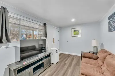 a living room with a couch and a flat screen tv at The Main Lineup Apt 4 - All Star Baseball Rentals in Oneonta