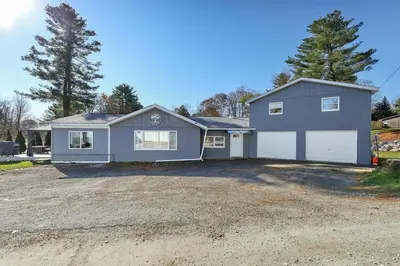 a large house with a garage in a driveway at 13-Min Jiminy, Fave, Hot Tub, Lg Open LR, Family in Pittsfield