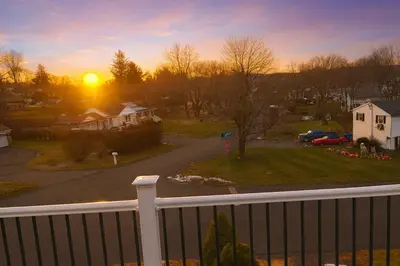 a view of the sunset from a balcony at Cozy Apartment in Watertown
