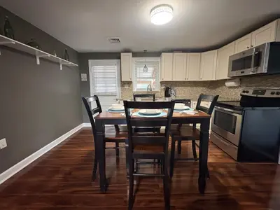 a kitchen with a table and chairs in a room at Cozy Apartment in Watertown