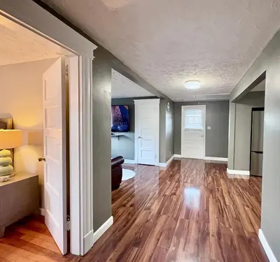 an empty living room with a hard wood floor at Cozy Apartment in Watertown