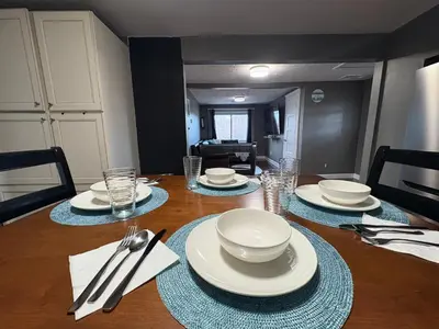 a dining room table with plates and silverware on it at Cozy Apartment in Watertown