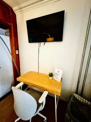 a table with two chairs and a television on a wall at Private Studio Near NYC - Easy Commute & Workspace in Guttenberg