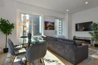 a living room with a couch and a glass table at Contemporary Luxury 3BR 2BA Downtown NYC in New York
