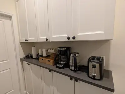 a kitchen counter with white cabinets and a coffee maker at The Midtown Sanctuary - Private Silent Suite at Times Square in New York