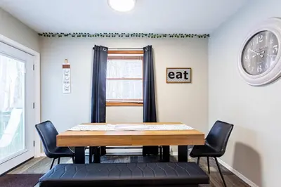 a dining room table with chairs and a clock on the wall at Summit Retreat Hot Tub Game Room Sauna in Tobyhanna