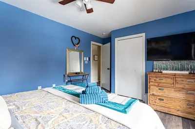 a blue bedroom with a bed and a dresser at Summit Retreat Hot Tub Game Room Sauna in Tobyhanna