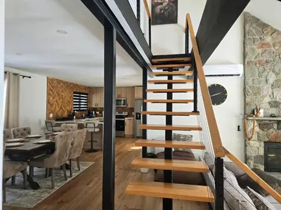 a staircase in a house with a dining room and kitchen at Pocono Ski Home Fire Pit Game Room EV in Tobyhanna