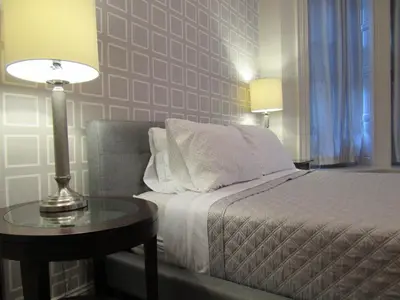 a bedroom with a bed and a table with a lamp at Washington Park Inn in Albany