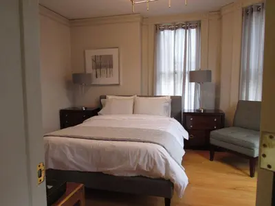 a bedroom with a large bed and a chair at Washington Park Inn in Albany