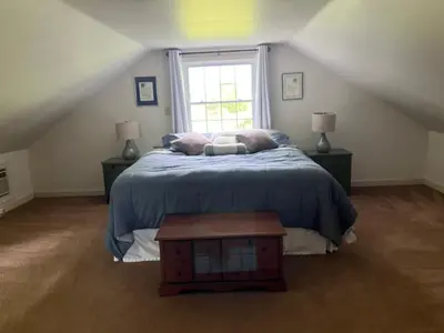 a bedroom with a bed with a blue blanket and a window at Peaceful Meadow Retreat in Granby