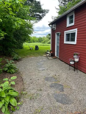 a red house with a bench and a picnic table at Peaceful Meadow Retreat in Granby