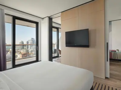 a bedroom with a large bed and a flat screen tv at The William Vale in Brooklyn