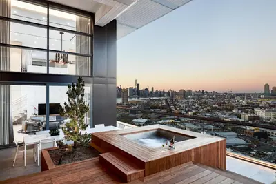 a hot tub in a room with a view of a city at The William Vale in Brooklyn