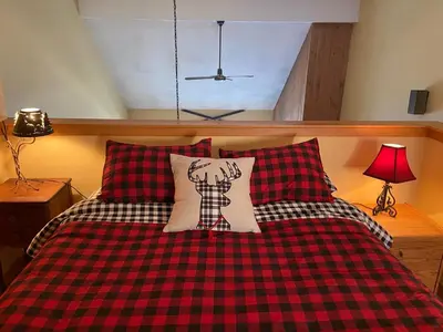 a bed with a red and black checkered blanket at Mount Snow Chalet Loft Condo With VIEW ! in Dover