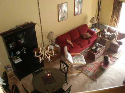 a living room with a red couch and a table at Mount Snow Chalet Loft Condo With VIEW ! in Dover