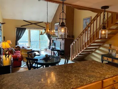a kitchen and living room with a staircase and a living room at Mount Snow Chalet Loft Condo With VIEW ! in Dover