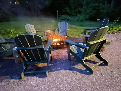 a group of chairs sitting around a fire pit at Cozy Lake House - Salisbury/Lakeville in Salisbury