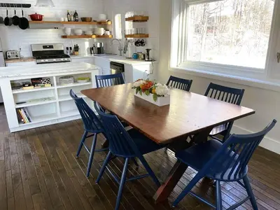 a kitchen with a wooden table and blue chairs at Cozy Lake House - Salisbury/Lakeville in Salisbury