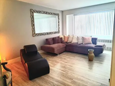 a living room with a purple couch and a chair at Piece of mind in Harlem in New York