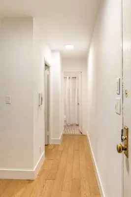 an empty hallway with white walls and wood floors at Piece of mind in Harlem in New York
