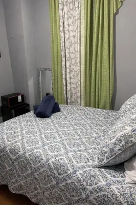a bedroom with a bed with a blue comforter at Room in a 2 Bedrooms Apartament Long Island City, Kitchen and Bathroom shared with very nice host in New York