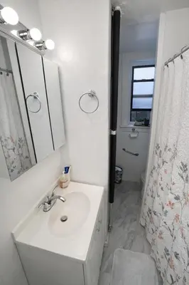 a white bathroom with a sink and a mirror at Room in a 2 Bedrooms Apartament Long Island City, Kitchen and Bathroom shared with very nice host in New York