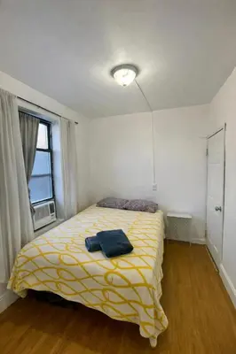 a bedroom with a bed with a yellow blanket at Room in a 2 Bedrooms Apartament Long Island City, Kitchen and Bathroom shared with very nice host in New York