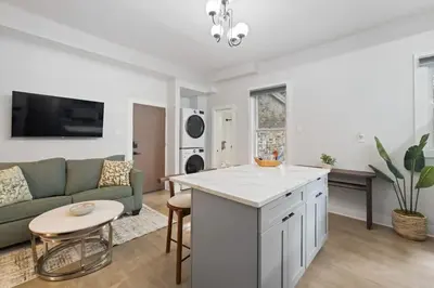 a kitchen and living room with a couch and a table at Cozy and Modern 3BR Apartment 5min to PATH to NYC in Jersey City