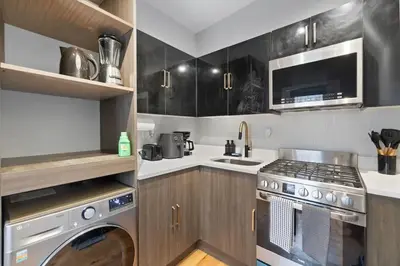 a kitchen with a stove top oven next to a sink at Modern & Cozy Studio in Jersey 20 Min to New York in Jersey City