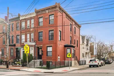 a red brick building on the corner of a street at Designer Luxury Duplex a few mintues to NYC with Skyline Views in Jersey City