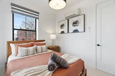 a bedroom with a bed and a large window at Designer Luxury Duplex a few mintues to NYC with Skyline Views in Jersey City