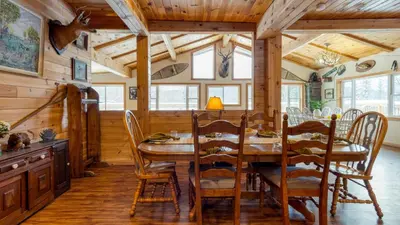a dining room with a wooden table and chairs at Mins to Hunter Mountain • Sleeps 36 • Pool Spa Games Bar Cozy Peaks Lodge by AvantStay in Tannersville