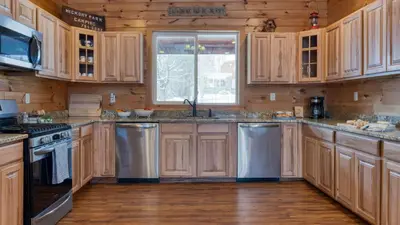 a kitchen with wooden cabinets and stainless steel appliances at Mins to Hunter Mountain • Sleeps 36 • Pool Spa Games Bar Cozy Peaks Lodge by AvantStay in Tannersville