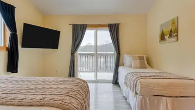 a bedroom with two beds and a window with a balcony at Mins to Hunter Mountain • Sleeps 36 • Pool Spa Games Bar Cozy Peaks Lodge by AvantStay in Tannersville