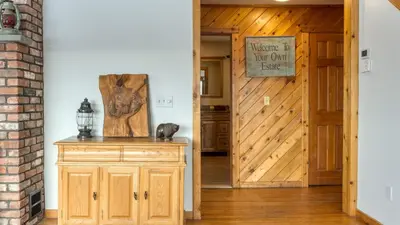 a hallway with a wooden door and a wooden cabinet at Scenic Catskills Retreat • Pool Hot Tub Game Room Lake Views Mountainview Estate by AvantStay in Jewett