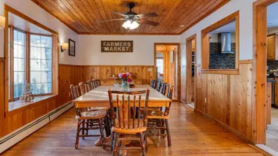a dining room with a wooden table and chairs at Scenic Catskills Retreat • Pool Hot Tub Game Room Lake Views Mountainview Estate by AvantStay in Jewett