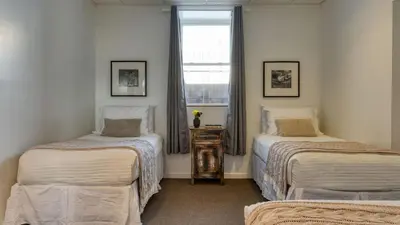 a bedroom with two twin beds and a window at Scenic Catskills Retreat • Pool Hot Tub Game Room Lake Views Mountainview Estate by AvantStay in Jewett