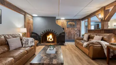 a living room with a couch and a fireplace at Sleeps 40 • Heated Pool • Hot Tub • Fire Pit • Game Room Brookside Mountain Retreat by AvantStay in Stephentown