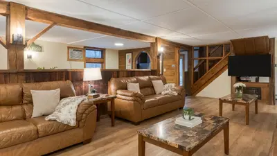 a living room with two couches and a tv at Sleeps 40 • Heated Pool • Hot Tub • Fire Pit • Game Room Brookside Mountain Retreat by AvantStay in Stephentown