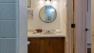 a bathroom with a sink and a mirror at Sleeps 40 • Heated Pool • Hot Tub • Fire Pit • Game Room Brookside Mountain Retreat by AvantStay in Stephentown