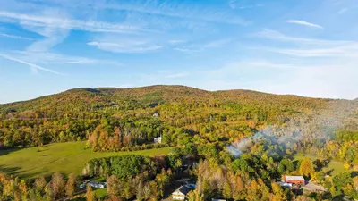 an aerial view of a mountain with trees and houses at Sleeps 40 • Heated Pool • Hot Tub • Fire Pit • Game Room Brookside Mountain Retreat by AvantStay in Stephentown