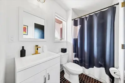 a bathroom with a white toilet and a blue shower curtain at Mediterranean villa hot tub fire place•fire pit in Monroe