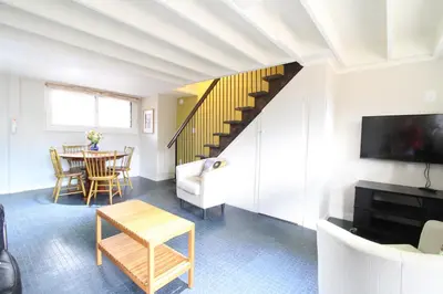 a living room with a table and a staircase at Fiber Artist's Studio in Woodstock